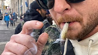 Ben Gilbert, 38 ans, fume de la marijuana dans le sud de Manhattan devant le premier dispensaire légal de marijuana récréative à New York, le jeudi 29 décembre 2022.