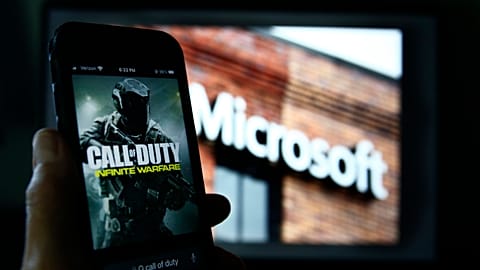 An image from Activision's Call of Duty is shown on a smartphone near a photograph of the Microsoft logo in this photo taken in New York, June 15, 2023. 