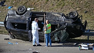 Police officers work at an accident site near an overturned mini bus on the motorway near Waldkraiburg in south, eastern Germany in October 13, 2023. 