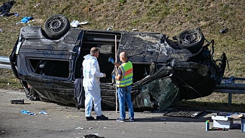 Police officers work at an accident site near an overturned mini bus on the motorway near Waldkraiburg in south, eastern Germany in October 13, 2023. 