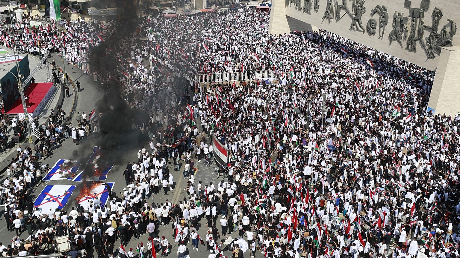 متظاهرون يحرقون الأعلام الإسرائيلية خلال مظاهرة في ساحة التحرير ببغداد في 13 أكتوبر، 2023