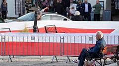 A man waits for the final election campaign rally of ruling PiS (Law and Justice) leader Jaroslaw Kaczynski, in Sandomierz, Poland, Friday, Oct. 13, 2023. 
