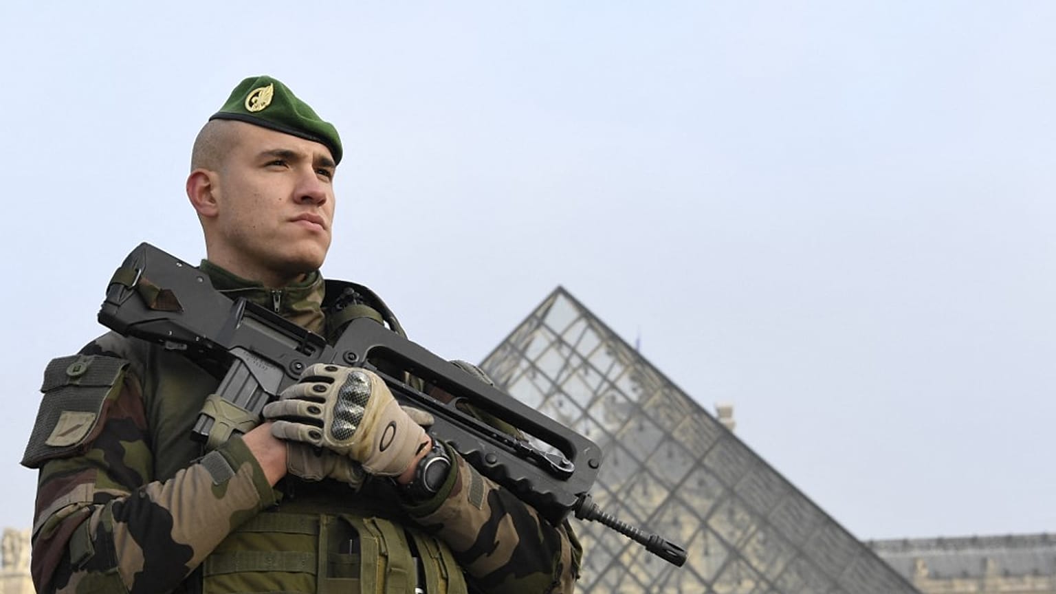 [Archives] Un soldat montant la garde à l'entrée de la Pyramide du Louvre, dans le cadre de l'opération Sentinelle, à Paris le 30 décembre 2016