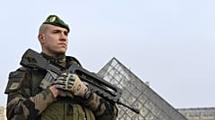 [Archives] Un soldat montant la garde à l'entrée de la Pyramide du Louvre, dans le cadre de l'opération Sentinelle, à Paris le 30 décembre 2016