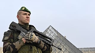 [Archives] Un soldat montant la garde à l'entrée de la Pyramide du Louvre, dans le cadre de l'opération Sentinelle, à Paris le 30 décembre 2016