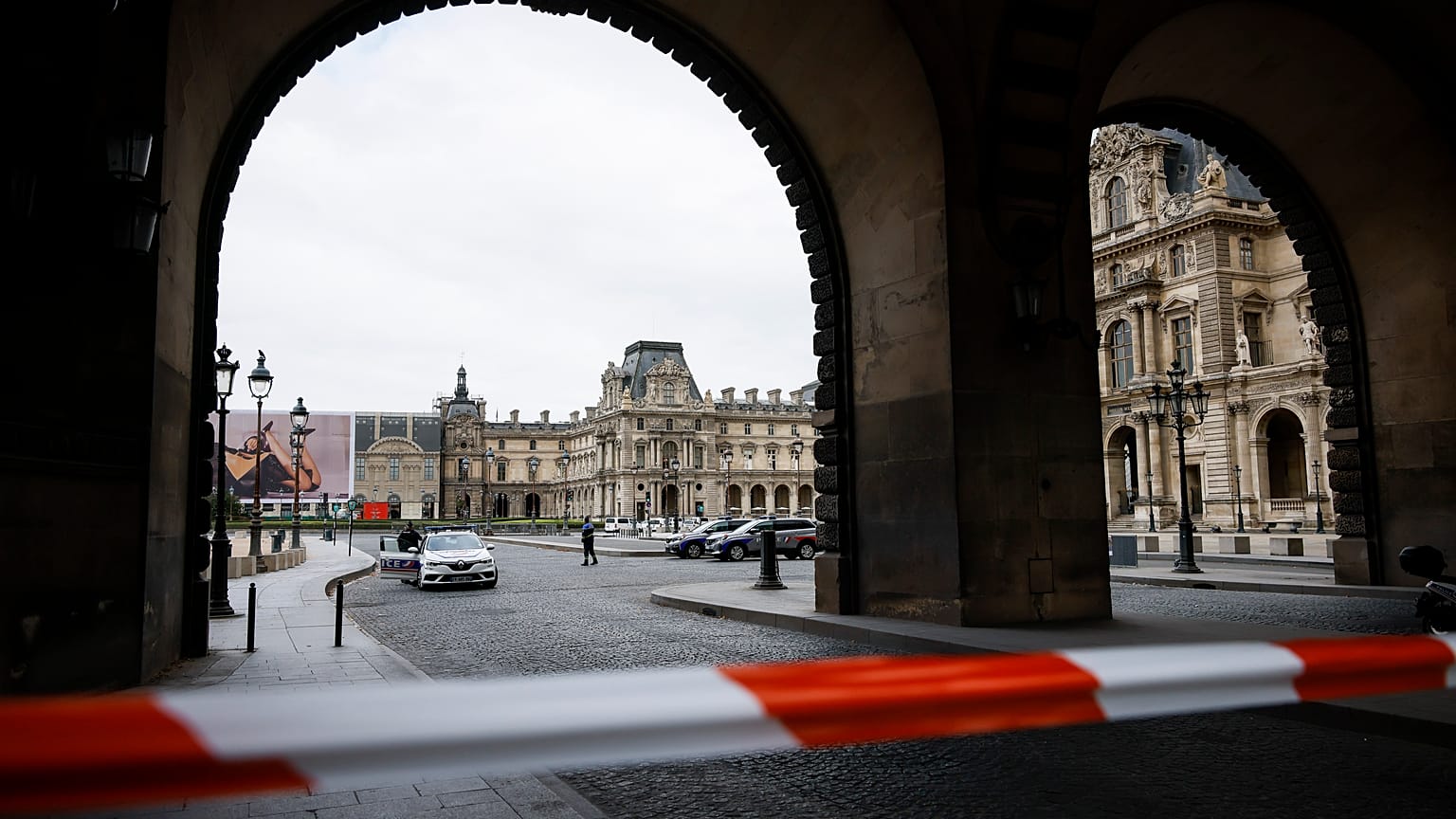 Police officers stand guard outside the Louvre Museum as people are evacuated after it received a written threat