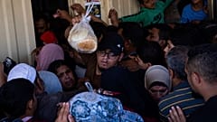 يصطف مئات الفلسطينيين أمام مخبز في خان يونس في قطاع غزة