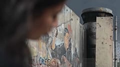 طفلة فلسطينية تجلس تحت الجدار العازل في الضفة الغربية المحتلة. 2023