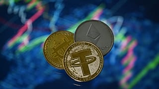 An illustration picture taken in London on May 8, 2022, shows gold plated souvenir cryptocurrency Tether (USDT), Bitcoin and Etherium coins.