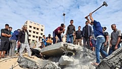 Palestinians look for survivors in buildings destroyed by Israeli airstrikes in Deir el-Balah, southern Gaza Strip