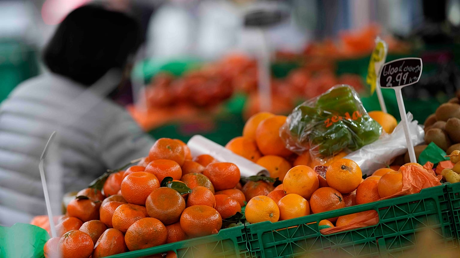 A woman looks at fruit and vegetables on sale at a stall in London, Tuesday, Feb. 28, 2023.