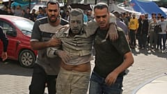 Dos personas trasladan a uno de los heridos en el hospital de Gaza