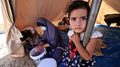 A young girl stands inside one of the tents set up for Palestinians on the grounds of a UNRWA centre in Khan Yunis.