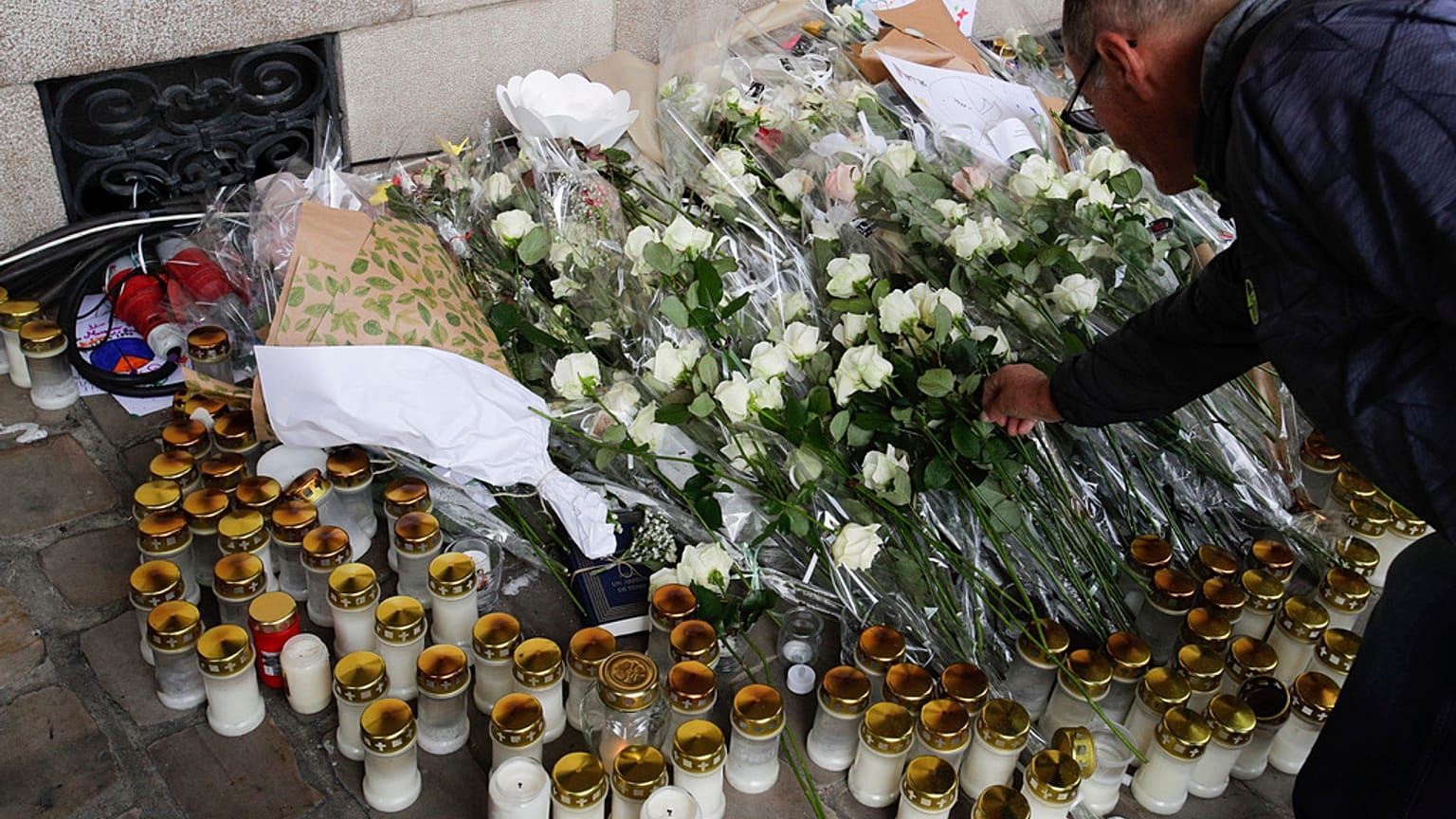 Un uomo depone un fiore per rendere omaggio all'insegnante francese Dominique Bernard durante il suo funerale, ad Arras, nel nord della Francia, 19 ottobre 2023