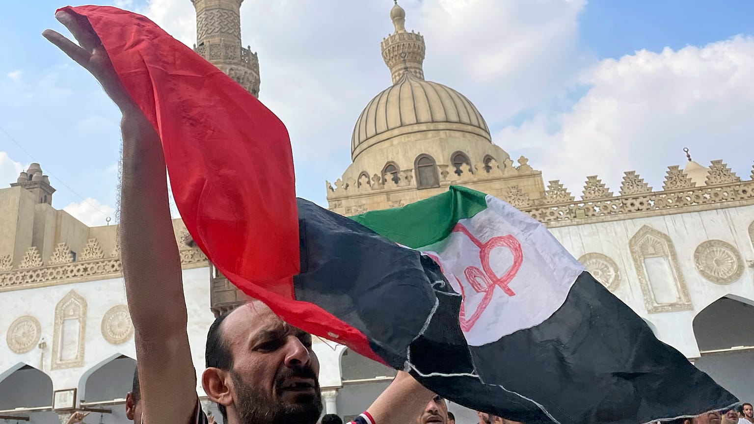 متظاهر يلوح بالعلم الفلسطيني مكتوب عليه "طوفان الأقصى" بعد صلاة الجمعة في الأزهر، المؤسسة الإسلامية الأولى في العالم الإسلامي السني، في القاهرة، مصر، الجمعة، 13 أكتوبر  2023