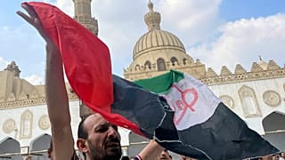 متظاهر يلوح بالعلم الفلسطيني مكتوب عليه "طوفان الأقصى" بعد صلاة الجمعة في الأزهر، المؤسسة الإسلامية الأولى في العالم الإسلامي السني، في القاهرة، مصر، الجمعة، 13 أكتوبر  2023