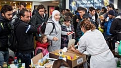 توزيع الطعام والشراب من قبل متطوعين على اللاجئين بعد وصولهم إلى محطة القطار في مالمو، السويد