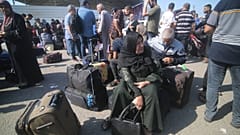 فلسطينينون ينتظرون في معبر رفح لمغادرة قطاع غزة.