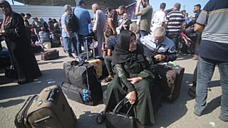 فلسطينينون ينتظرون في معبر رفح لمغادرة قطاع غزة.