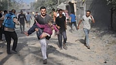 Homem palestiniano transporta rapaz ferido durante bombardeamento de Israel à Faixa de Gaza