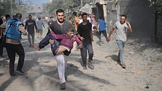 Homem palestiniano transporta rapaz ferido durante bombardeamento de Israel à Faixa de Gaza