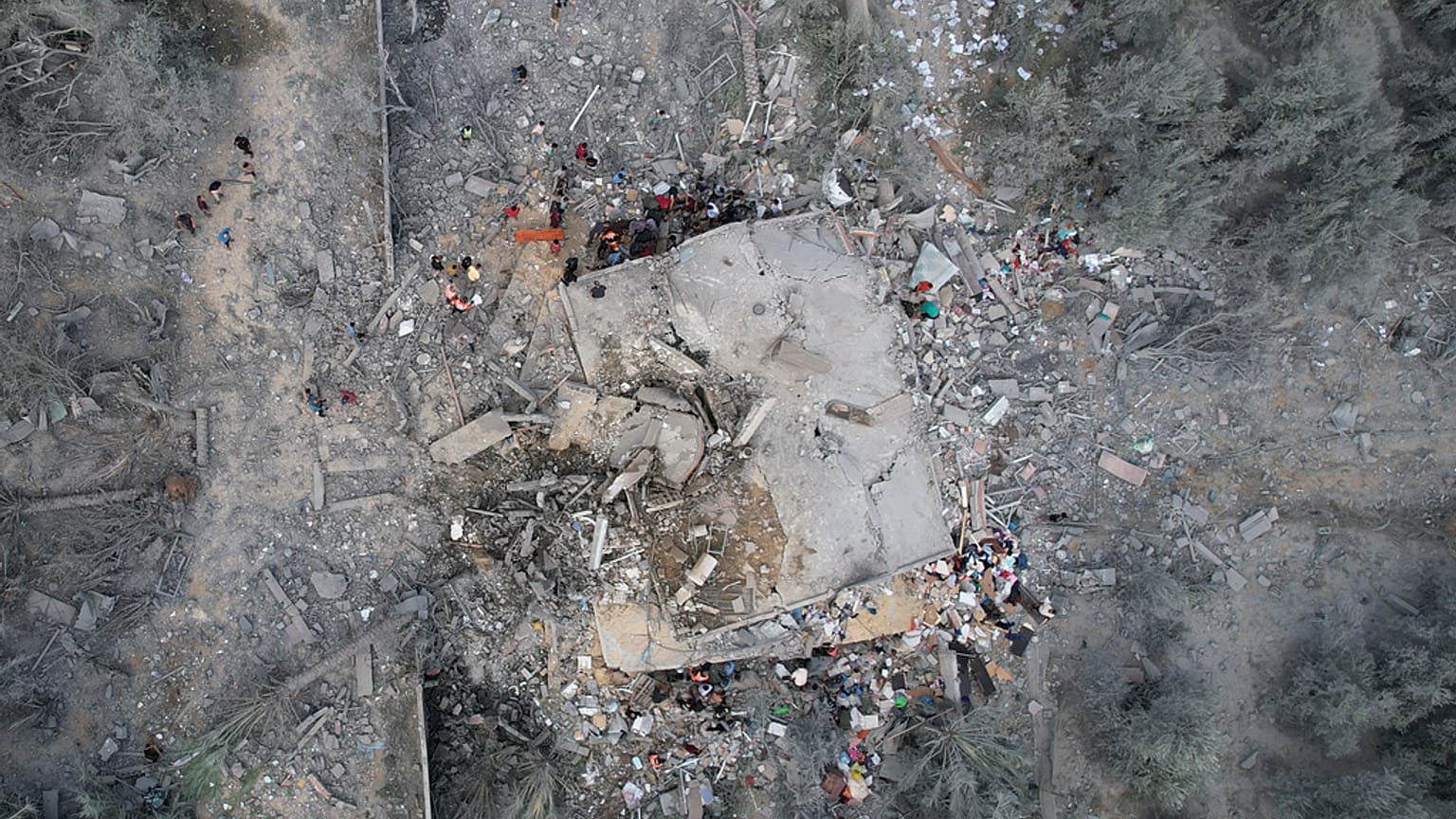 Palestinos buscan supervivientes tras el bombardeo israelí de la Franja de Gaza en Deir Al-Balah, domingo 22 de octubre de 2023.