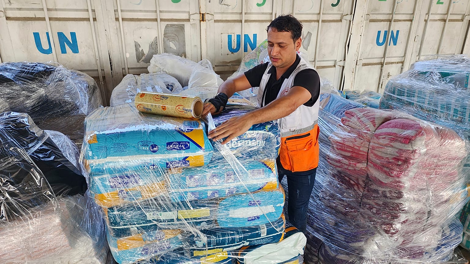 Gazze'de Birleşmiş Milletler Filistinli Mültecilere Yardım Kuruluşu (UNRWA) tarafından yapılan gıga yardımını alan Filistinli bir kadın