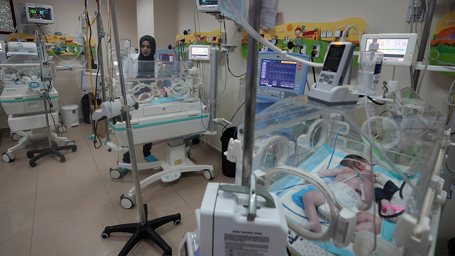 أطباء فلسطينيون يعالجون طفلًا مولودًا قبل الأوان في مستشفى الأقصى في دير البلح بقطاع غزة، الأحد 22 أكتوبر 2023.