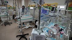 أطباء فلسطينيون يعالجون طفلًا مولودًا قبل الأوان في مستشفى الأقصى في دير البلح بقطاع غزة، الأحد 22 أكتوبر 2023.