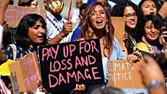 Mitzi Jonelle Tan (centre) a Filipino climate justice activist, joins a protest calling for a new loss and damage fund at COP27.