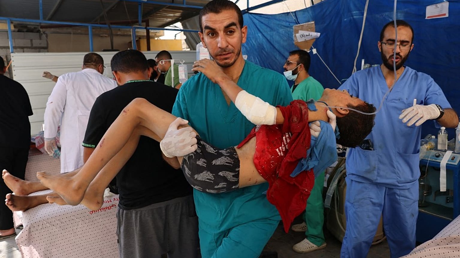 Des membres d'une équipe médicale transportent un garçon blessé par une frappe israélienne dans une salle d'urgence improvisée à l'extérieur de l'hôpital Koweït, à Rafah,.