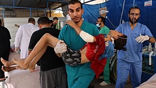 Des membres d'une équipe médicale transportent un garçon blessé par une frappe israélienne dans une salle d'urgence improvisée à l'extérieur de l'hôpital Koweït, à Rafah,.