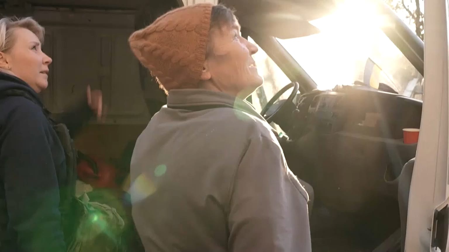 Volunteer Olga and a resident of Avdiivka anxiously check the sky for shells, Avdiivka, Ukraine, October 22, 2023