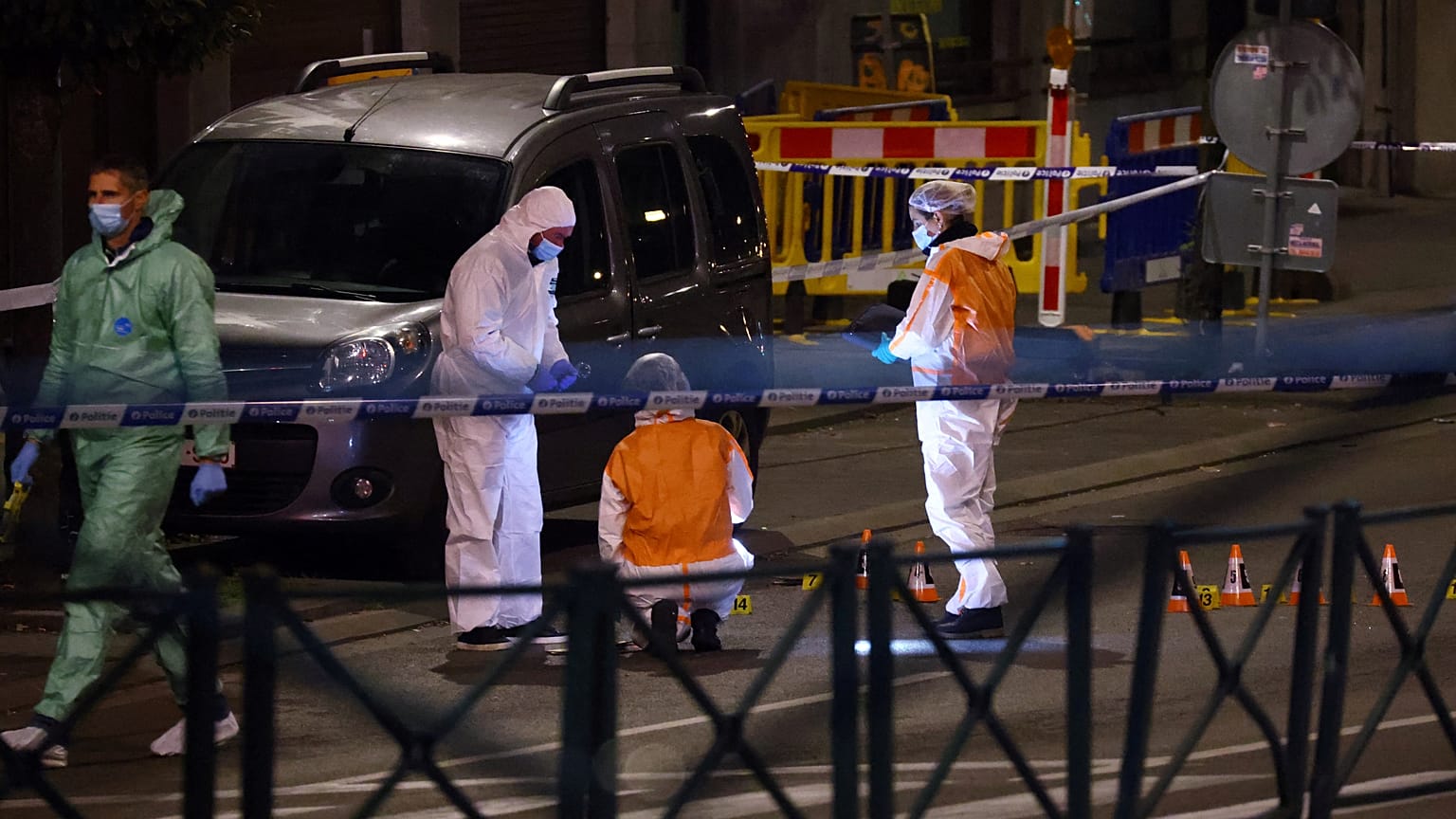 Belgian police officers from the forensic service search for evidence in a street after two people were killed during a shooting in Brussels on October 16, 2023.