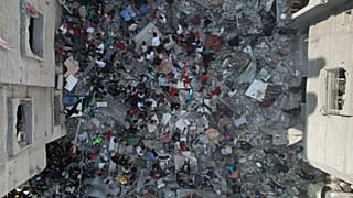 Palestinianos procuram sobreviventes dos bombardeamentos israelitas na Faixa de Gaza no campo de refugiados de Nusseirat, esta terça-feira