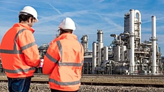 Travailleurs devant une usine chimique.