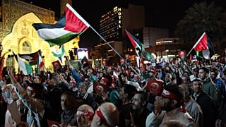 A Hezbollah iráni támogatói palesztin zászlóval ünnepelnek Teheránban 2023. október 7-én. 