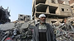Um palestiniano diante de um edifício destruído em Rafah