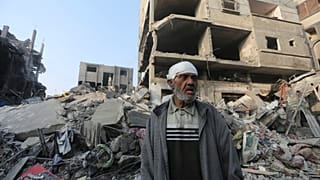Um palestiniano diante de um edifício destruído em Rafah