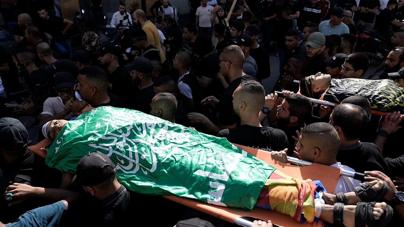 فلسطينيون يحملون جثث نشطاء قتلوا في غارة جوية إسرائيلية على مخيم اللاجئين في جنين