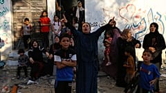 Palestinian women and children react following Israeli airstrikes targeting their neighbourhood in Gaza City, Saturday, Oct. 21, 2023. 