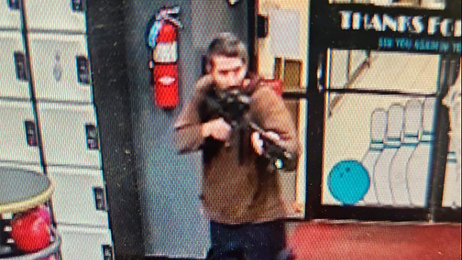 O atirador empunhando a arma à entrada no salão de "nowling"