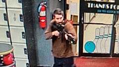 O atirador empunhando a arma à entrada no salão de "nowling"