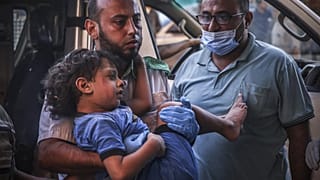 Criança palestiniana é levada para o hospital após ataques aéreos de Israel ao campo de refugiados de Khan Yunis, na Faixa de Gaza