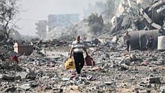 رجل فلسطيني يمشي بين أنقاض وركام في مدينة غزة 