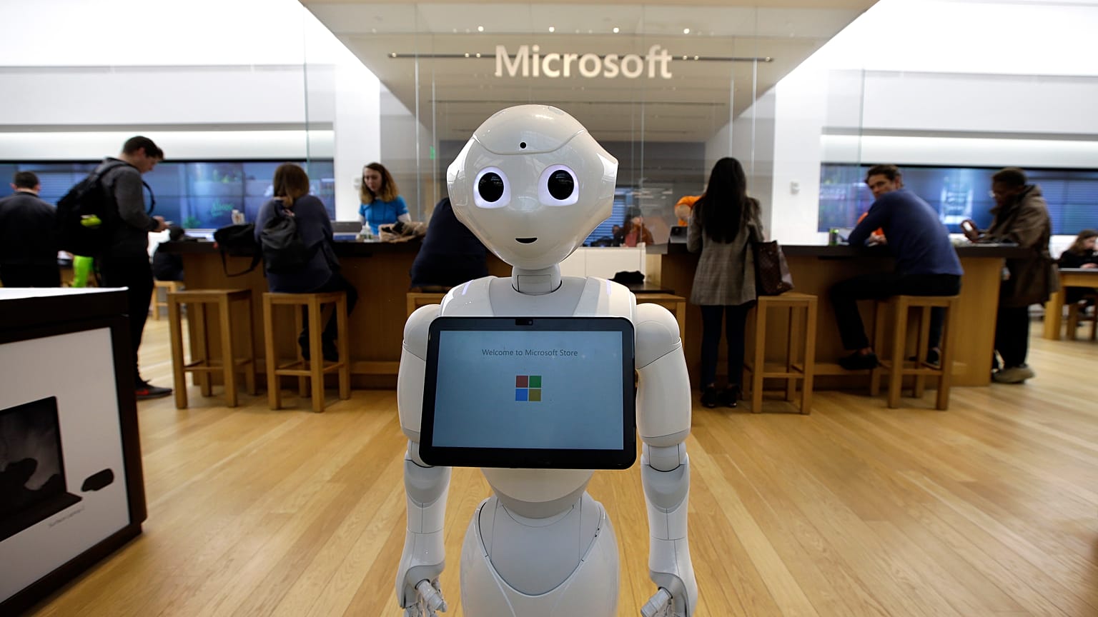 In this March 21, 2019 photo a robot called "Pepper" is positioned near an entrance to a Microsoft Store location, in Boston.