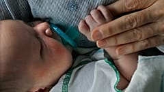 A volunteer baby holder carries a newborn who had been crying in the Texas Children's Hospital neonatal intensive care unit, 2007.