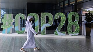 A person walks past a "#COP28" sign during an event in Abu Dhabi, United Arab Emirates, 1 October 2023.