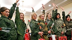 DATEI - Von Russland unterstützte Rebellenkämpferinnen winken, während sie nach einem Schönheitswettbewerb, an dem Frauen aus den wichtigsten separatistischen Bataillonen teilnahmen, in Donezk, Ukraine, 2015 für die Medien posieren.