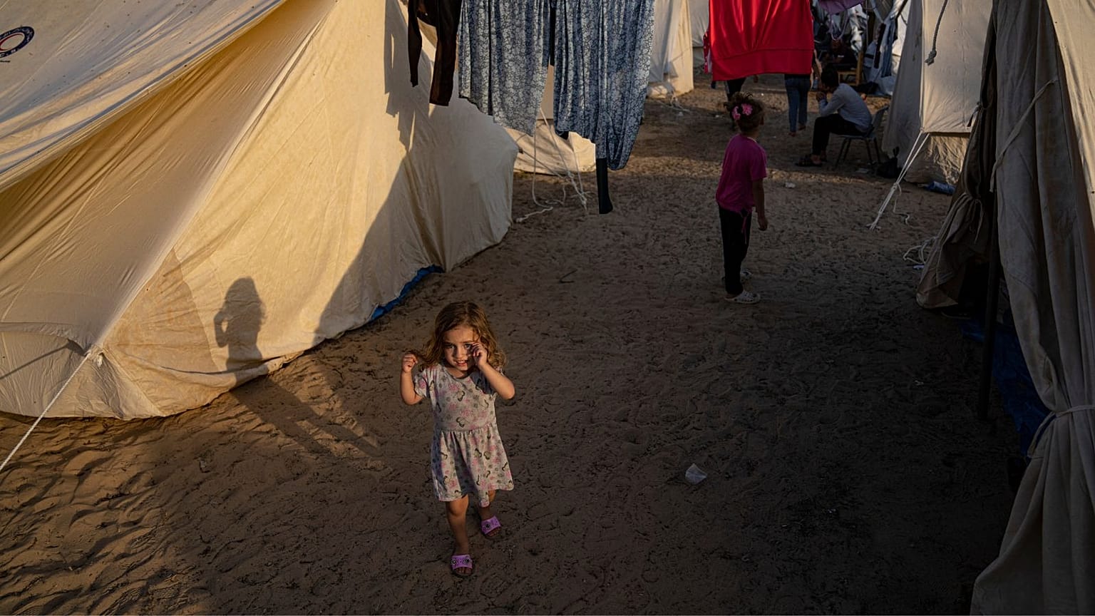 Palestinian children displaced by the Israeli bombardment of the Gaza Strip walk in a UNDP-provided tent camp in Khan Younis on Thursday, Oct. 19, 2023.